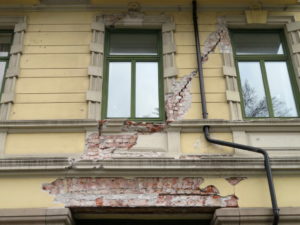 Bygård med avskalling, sprekker på fasaden,